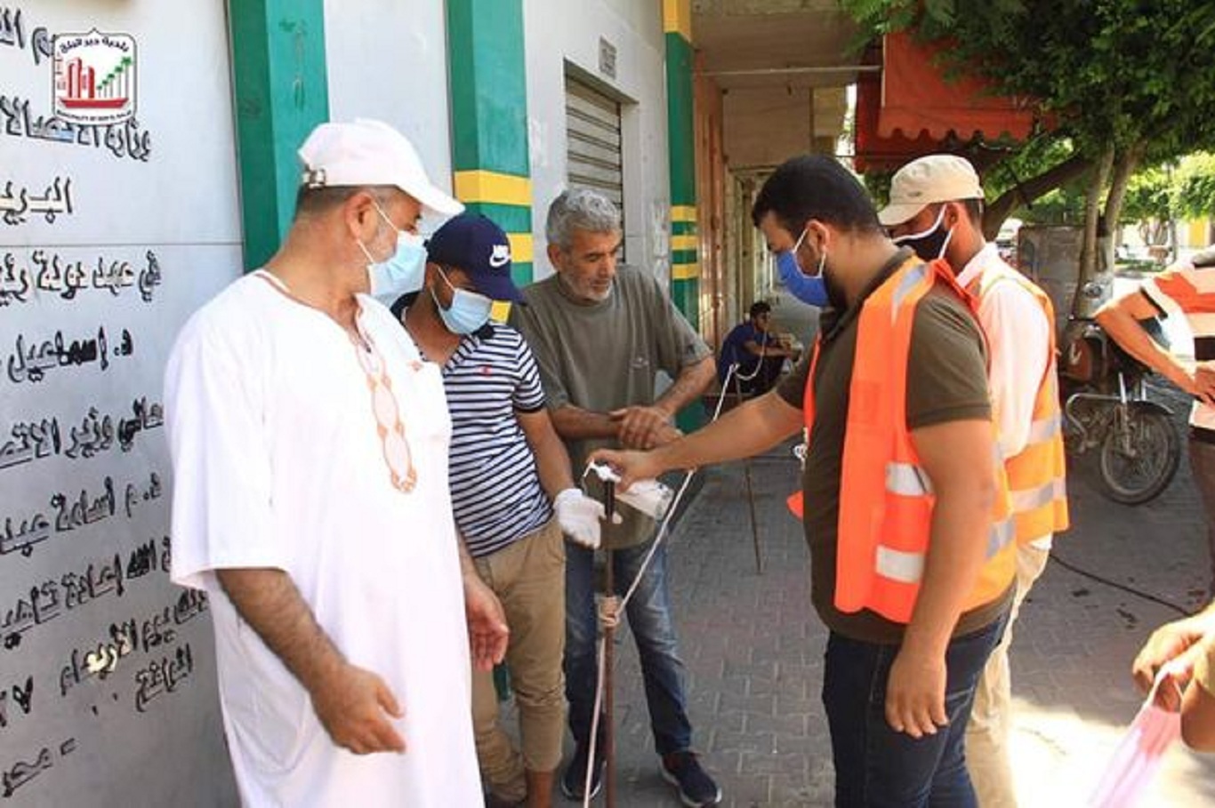 بلدية دير البلح توزع كمامات طبية على المواطنين المتواجدين امام البنوك
